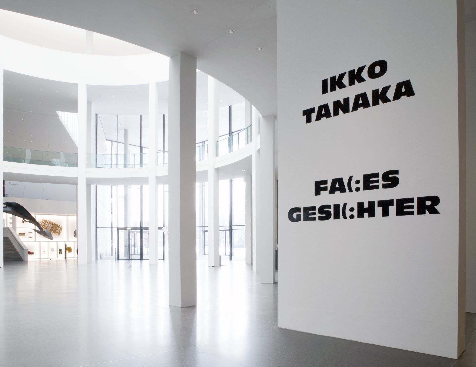 Wand mit Beschriftung auf Deutsch Ikko Tanaka Faces Gesichter