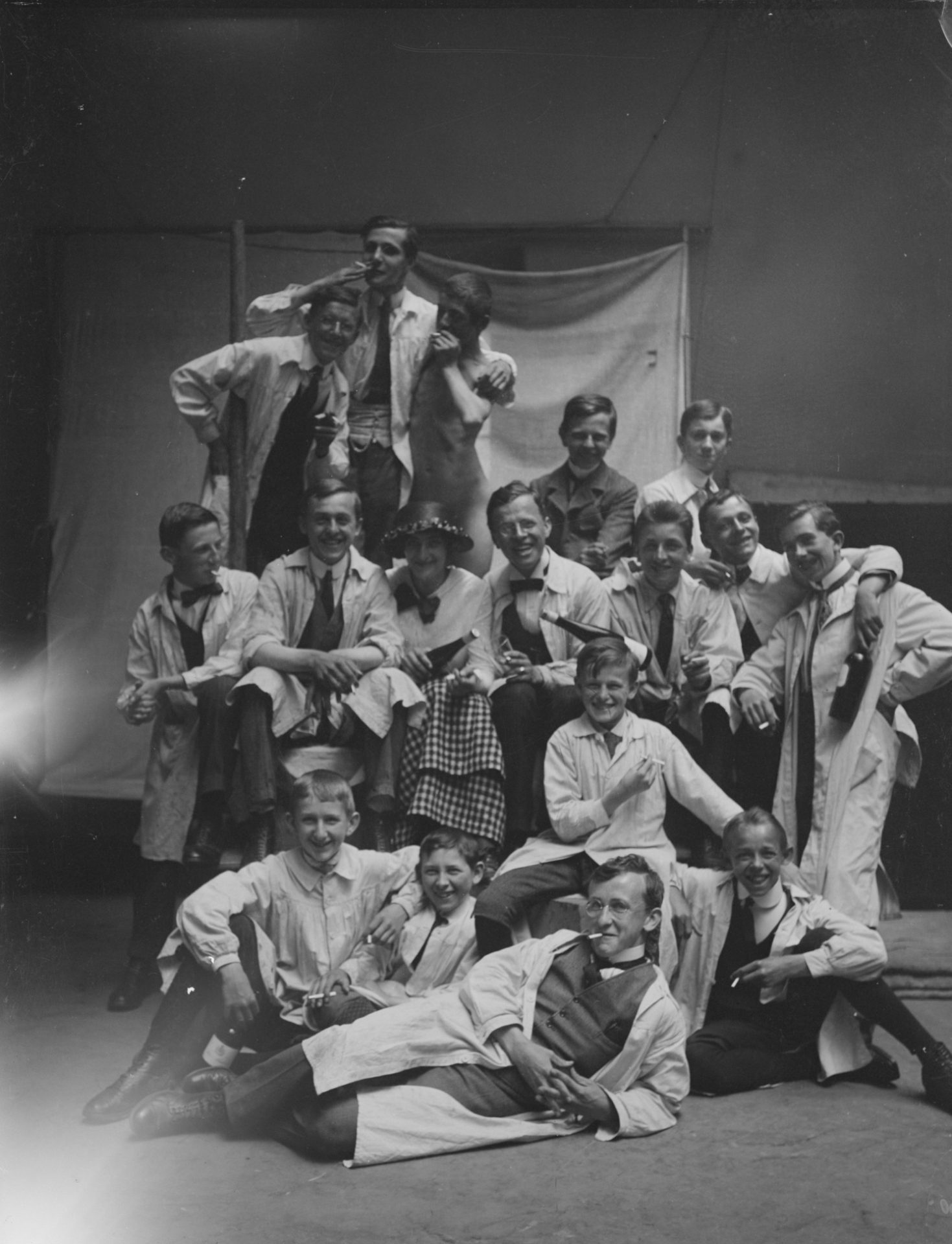 Shows young men at a studio party, black and white photography, the men look in a good mood.