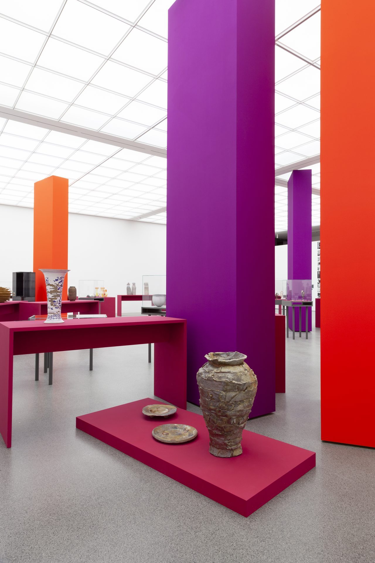 View of the exhibition "Danner Prize 2020. 100 years of the Danner Foundation", red and purple columns in the room, the objects are displayed on pink pedestals/showcases. A vase in the foreground.