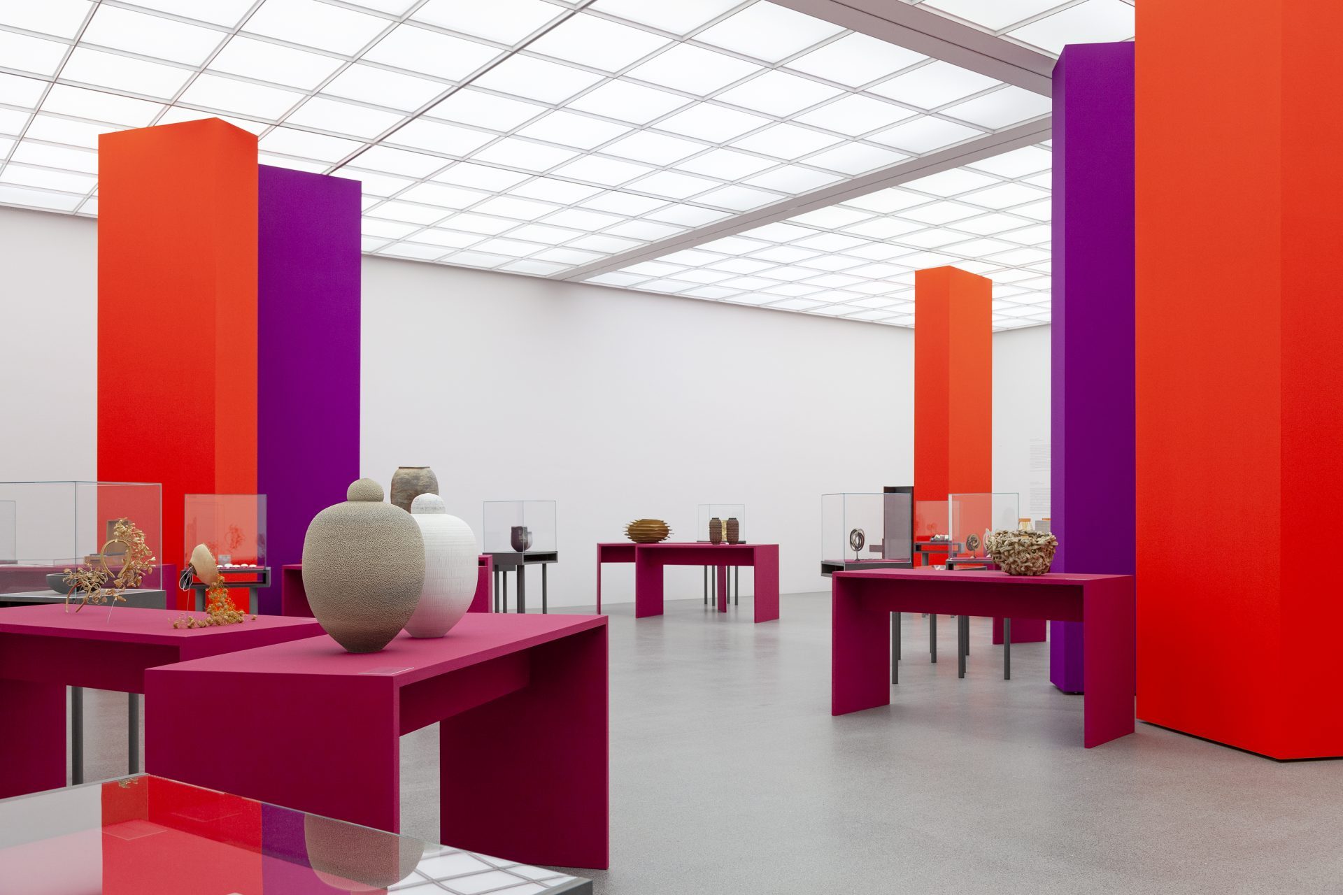 View of the exhibition "Danner Prize 2020. 100 years of the Danner Foundation", red and purple columns in the room, the objects are displayed on pink pedestals/showcases.