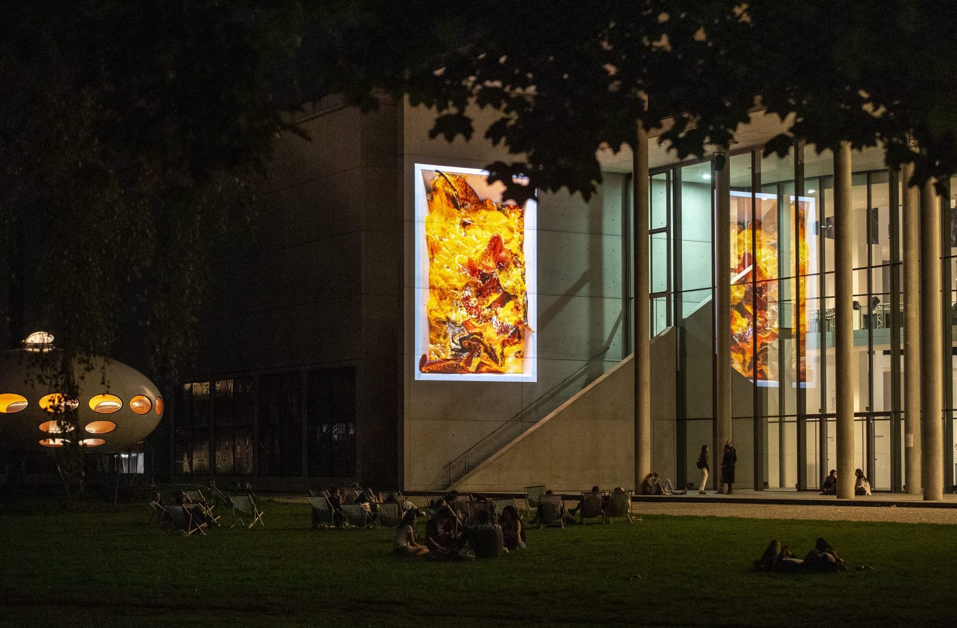 Data sculpture projected onto the north side of the Pinakothek der Moderne. With the help of data-based, machine learning algorithms, the flat projection continuously generates new, seemingly three-dimensional spaces. Different arrangements with ever-changing colour constellations and patterns are constantly created from the data to a random rhythm. Abstract images develop from moving lines, surfaces, waves or vortices that, through their dynamics, seem to dissolve the wall, causing a suction effect.