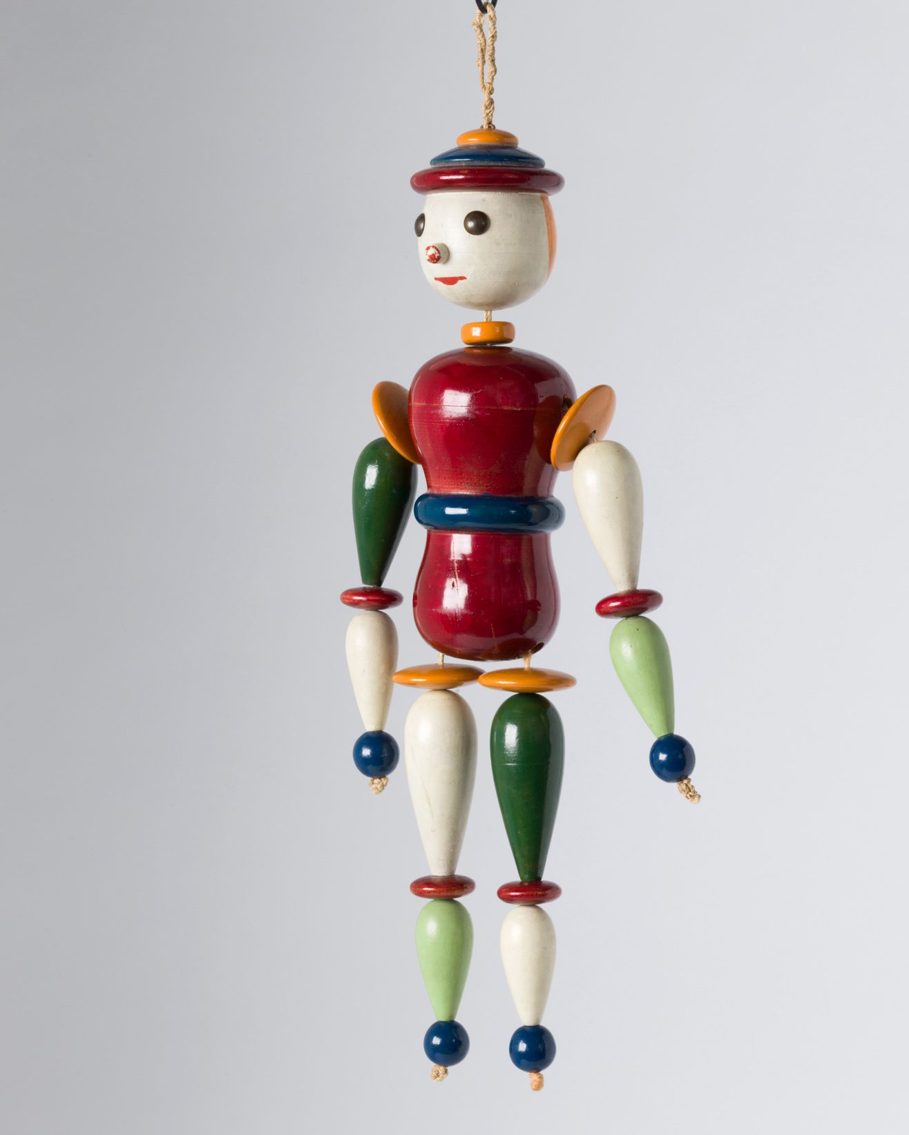 Colorful jointed doll made of wood. Egg-shaped head, vase-shaped body, cudgel-shaped arms and legs, spherical joints. The extreme colorfulness may possibly have been intended as a tribute to a child’s toy.