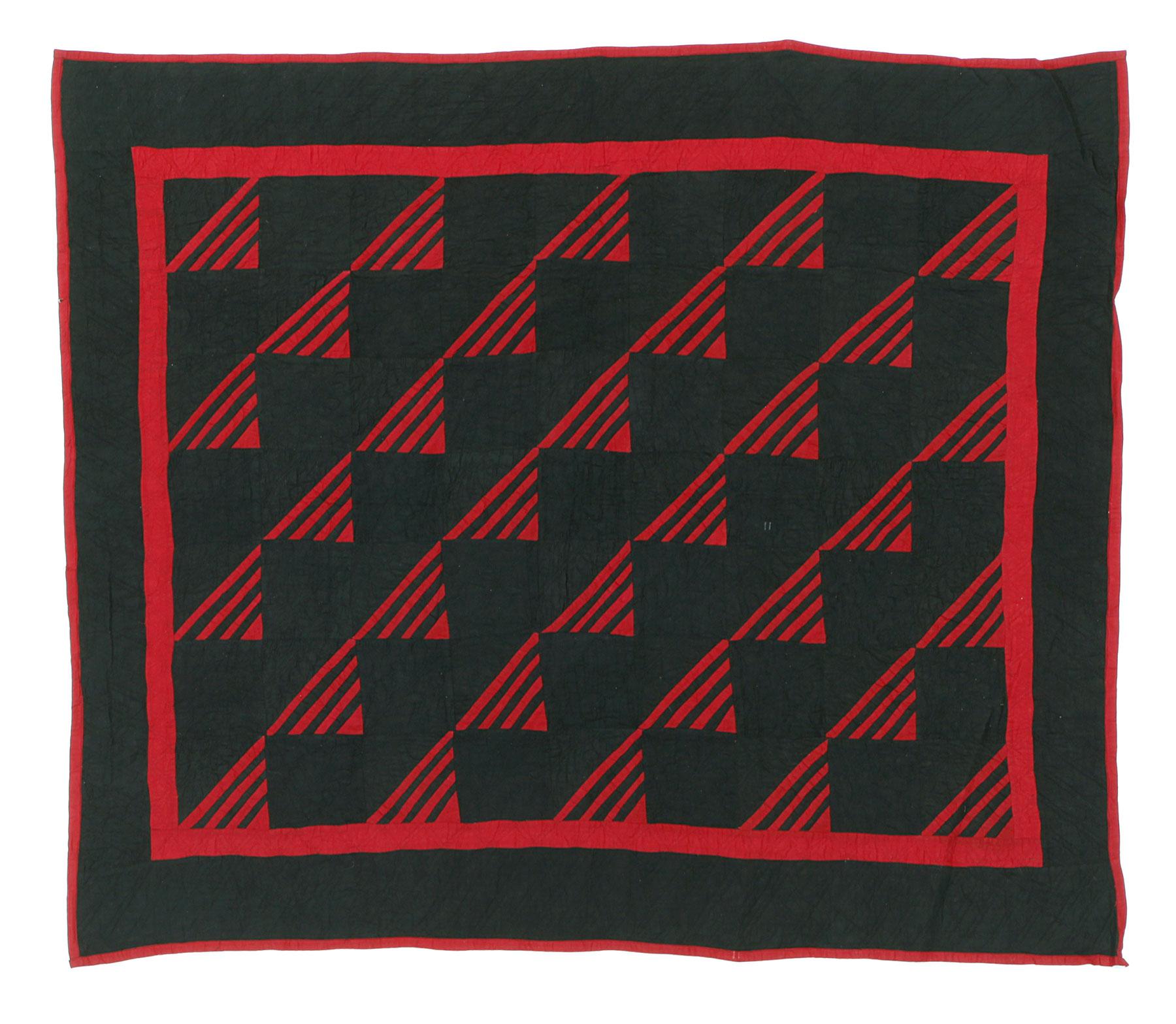 Handmade black blanket with a geometric pattern of red triangles and stripes, framed by a red border.