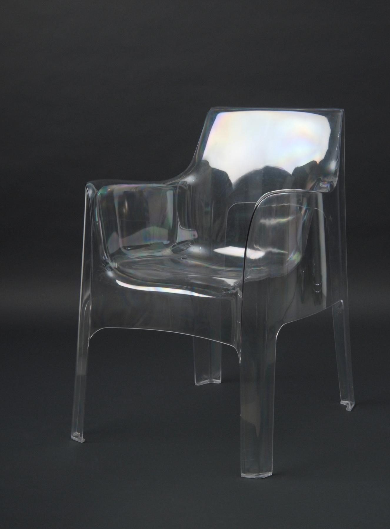 Transparent chair with angular shape and armrests, frontal.