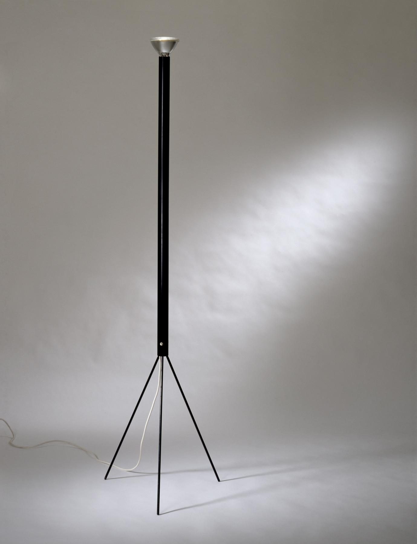 Slim, black floor lamp with three metal legs and upward-facing reflector lamp.