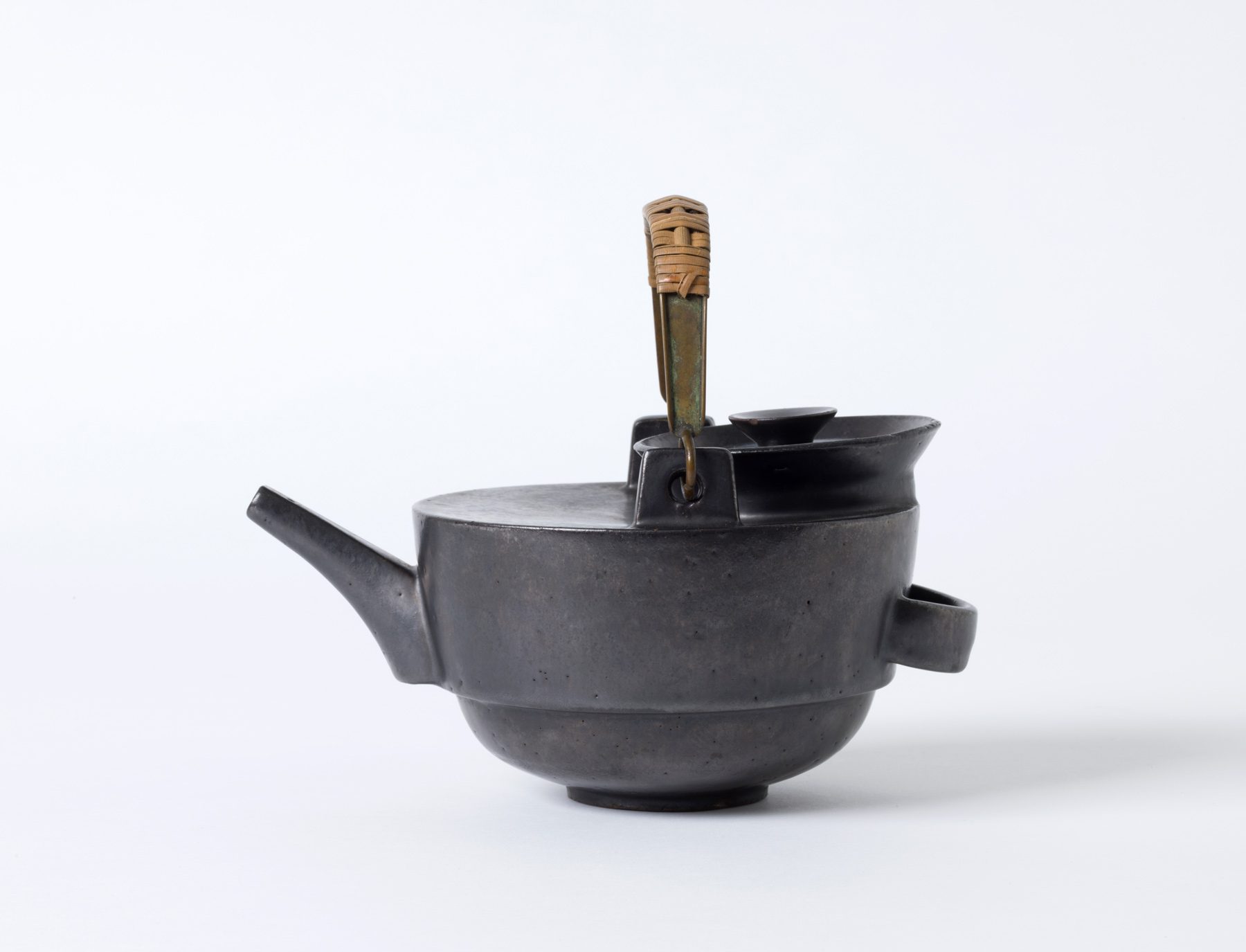 Photo black teapot with handle. There is a mesh around the handle for insulation.