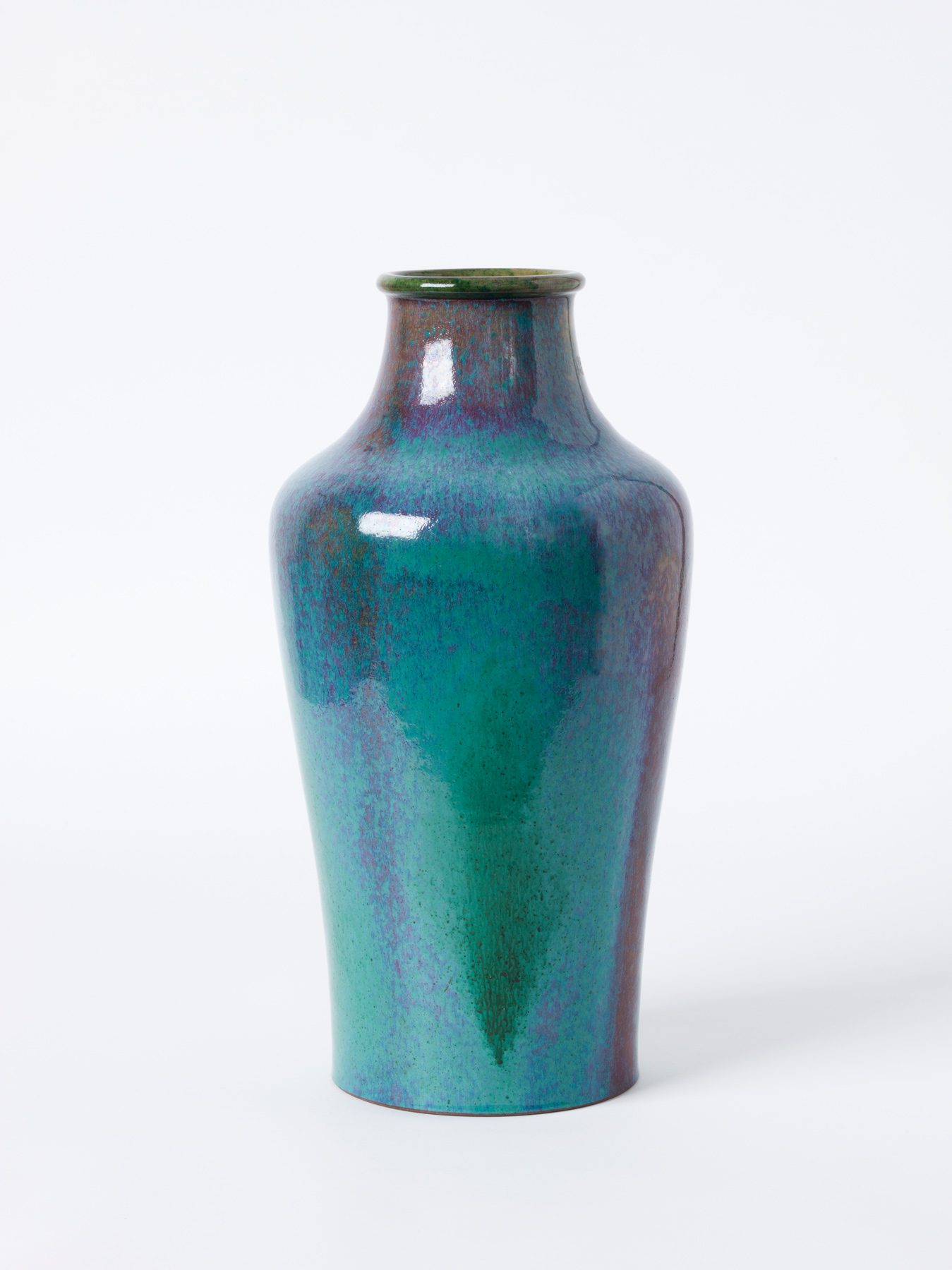 Keramikvase mit schimmernder Glasur in Blau- und Grüntönen. Die Vase hat eine geschwungene Silhouette mit schmalem Hals und leicht ausgestelltem Rand.